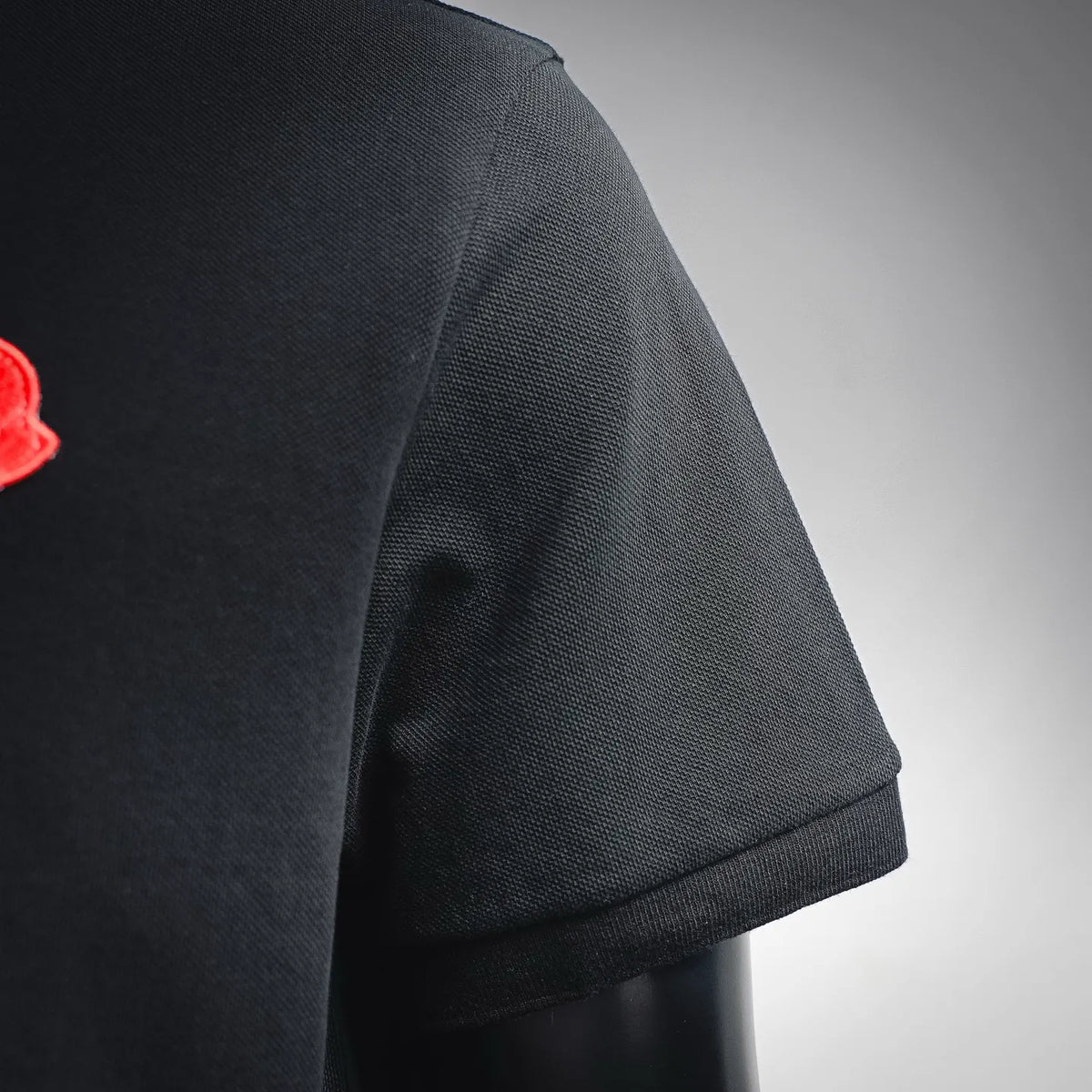 Black short polo sleeve with ribbed cuff and stitched hem