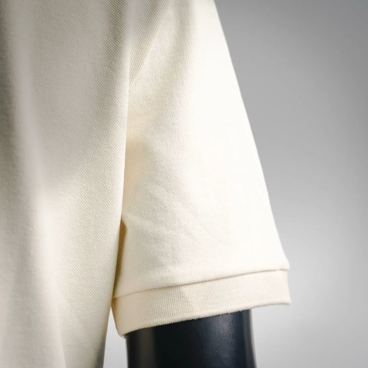 Moncler polo shirt sleeve cuff close-up, light cream knit rib trim