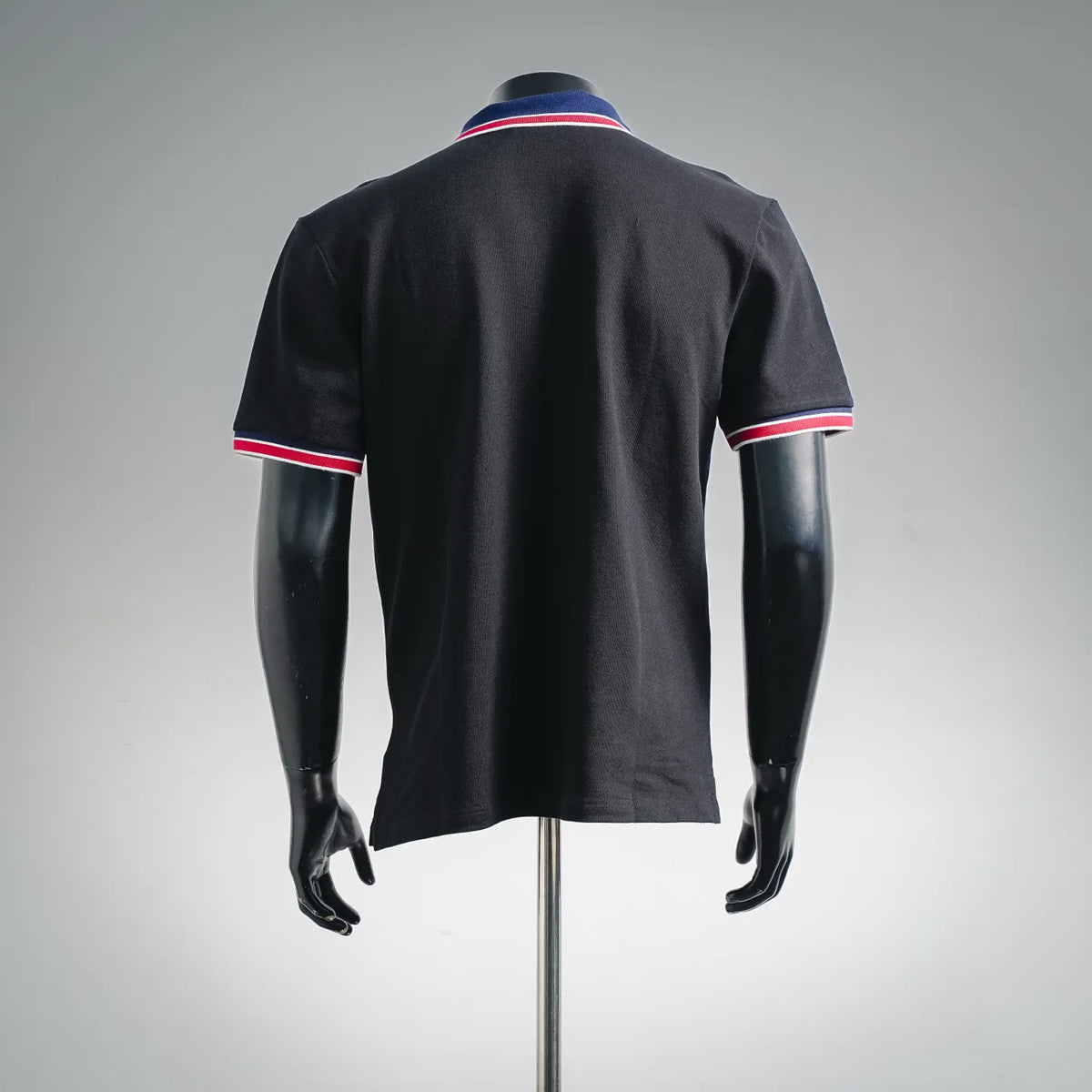 Black short-sleeve polo shirt back view with blue-red striped sleeve hems and collar