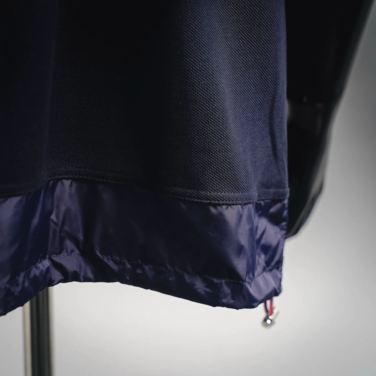 Moncler navy polo hem with contrast fabric lining and drawstring cord