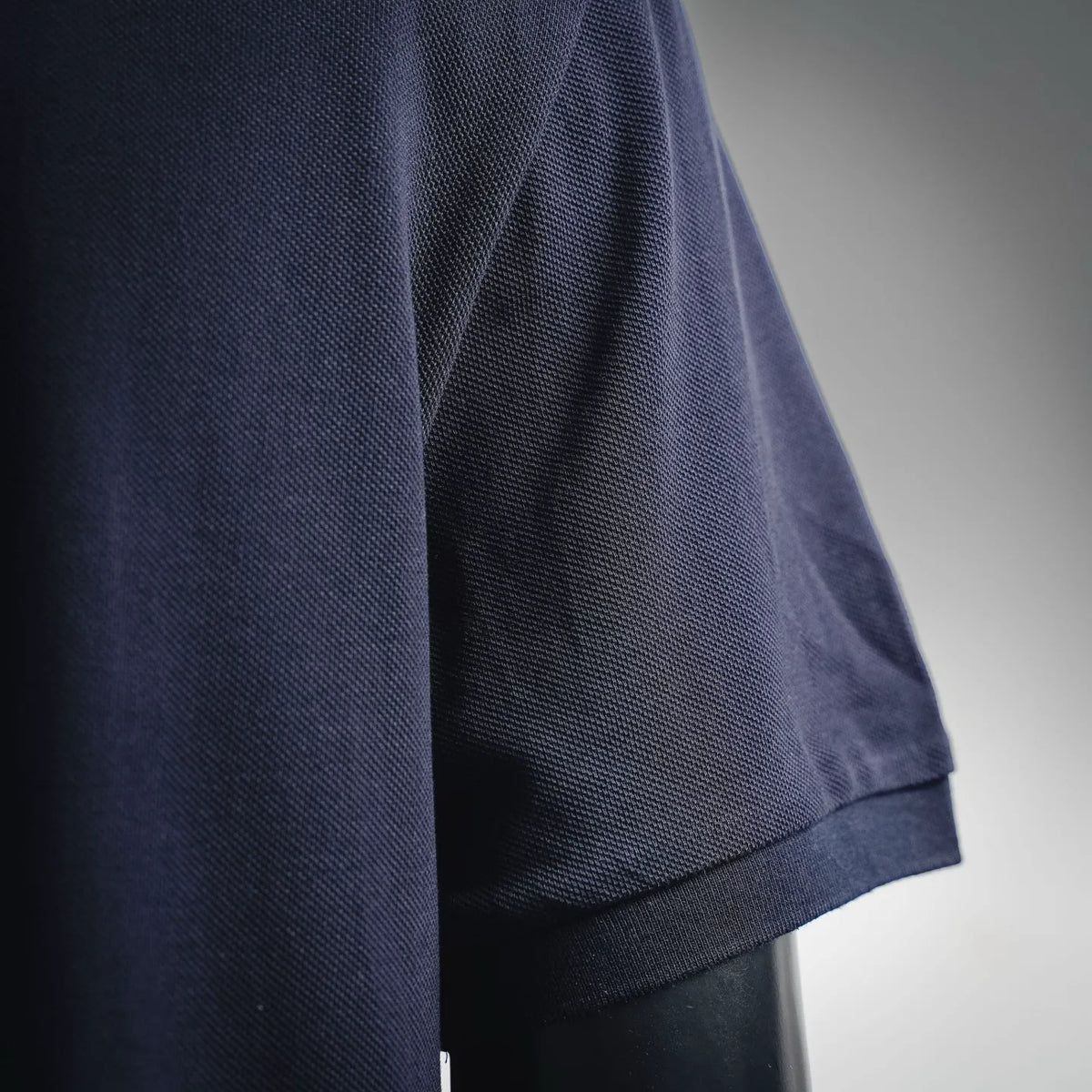 Moncler navy short-sleeve polo with ribbed cuff and textured knit fabric