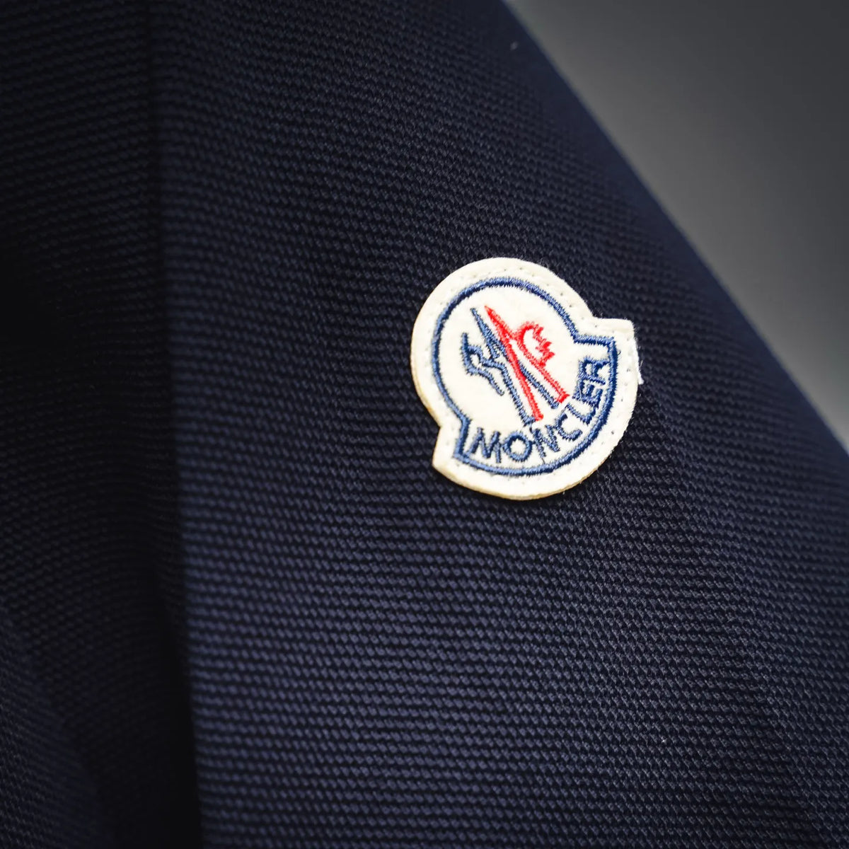 Moncler logo patch on navy polo sleeve