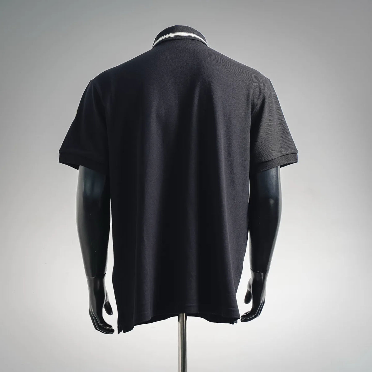 Dark polo shirt back view with ribbed collar trim and short sleeves