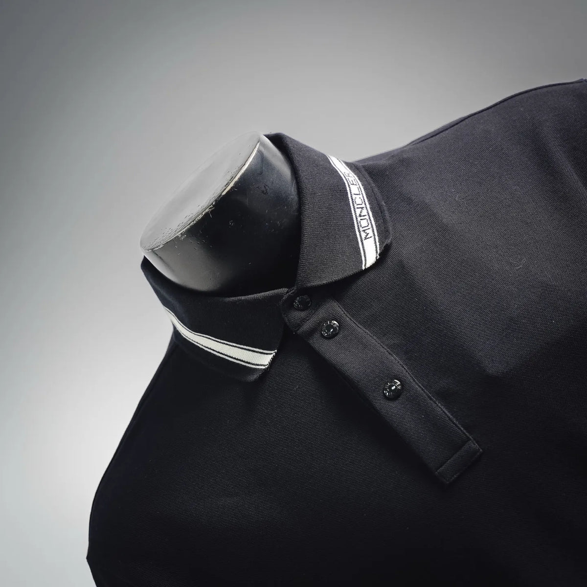 Polo collar and button placket with striped trim on dark fabric