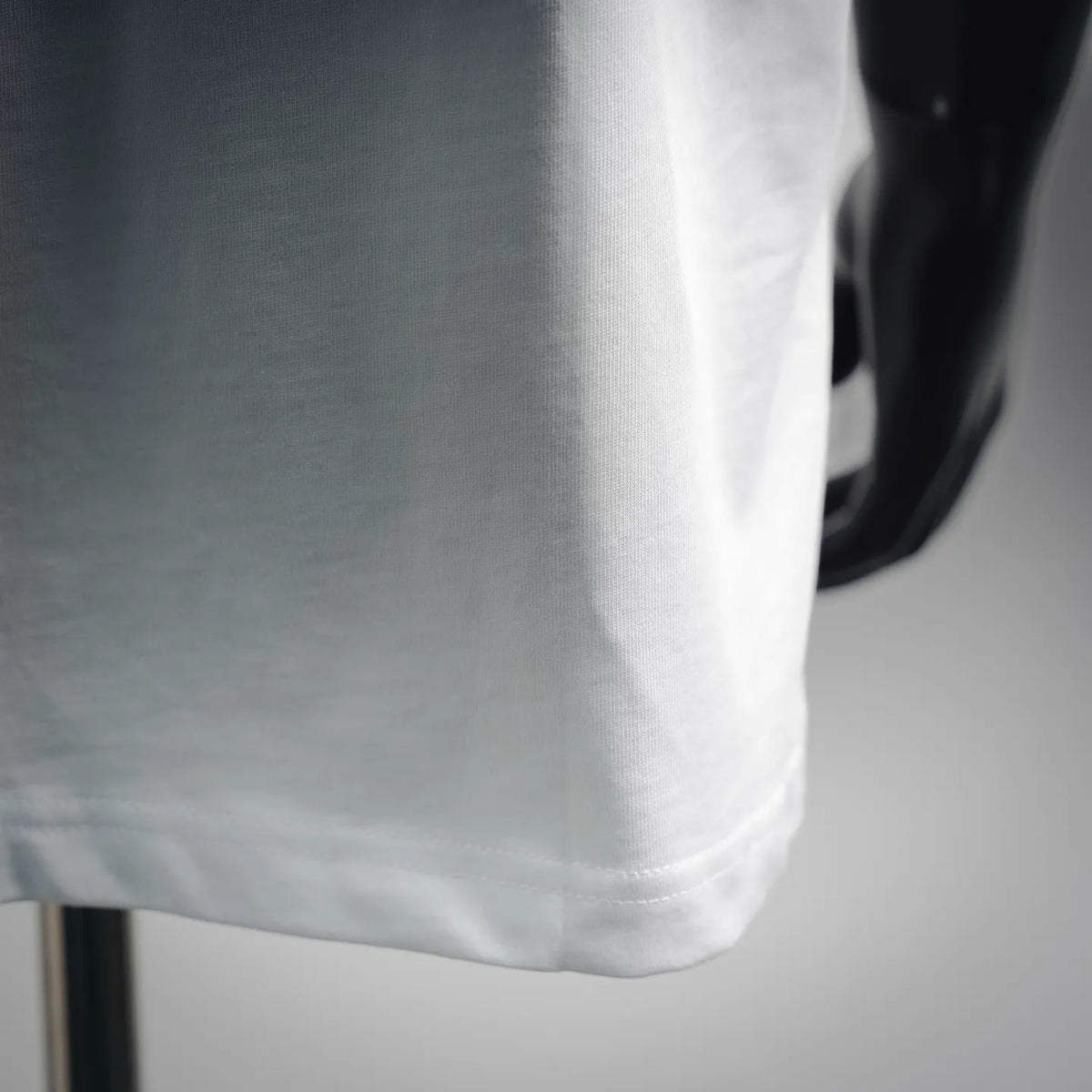 White T-shirt fabric close-up with straight hem stitching