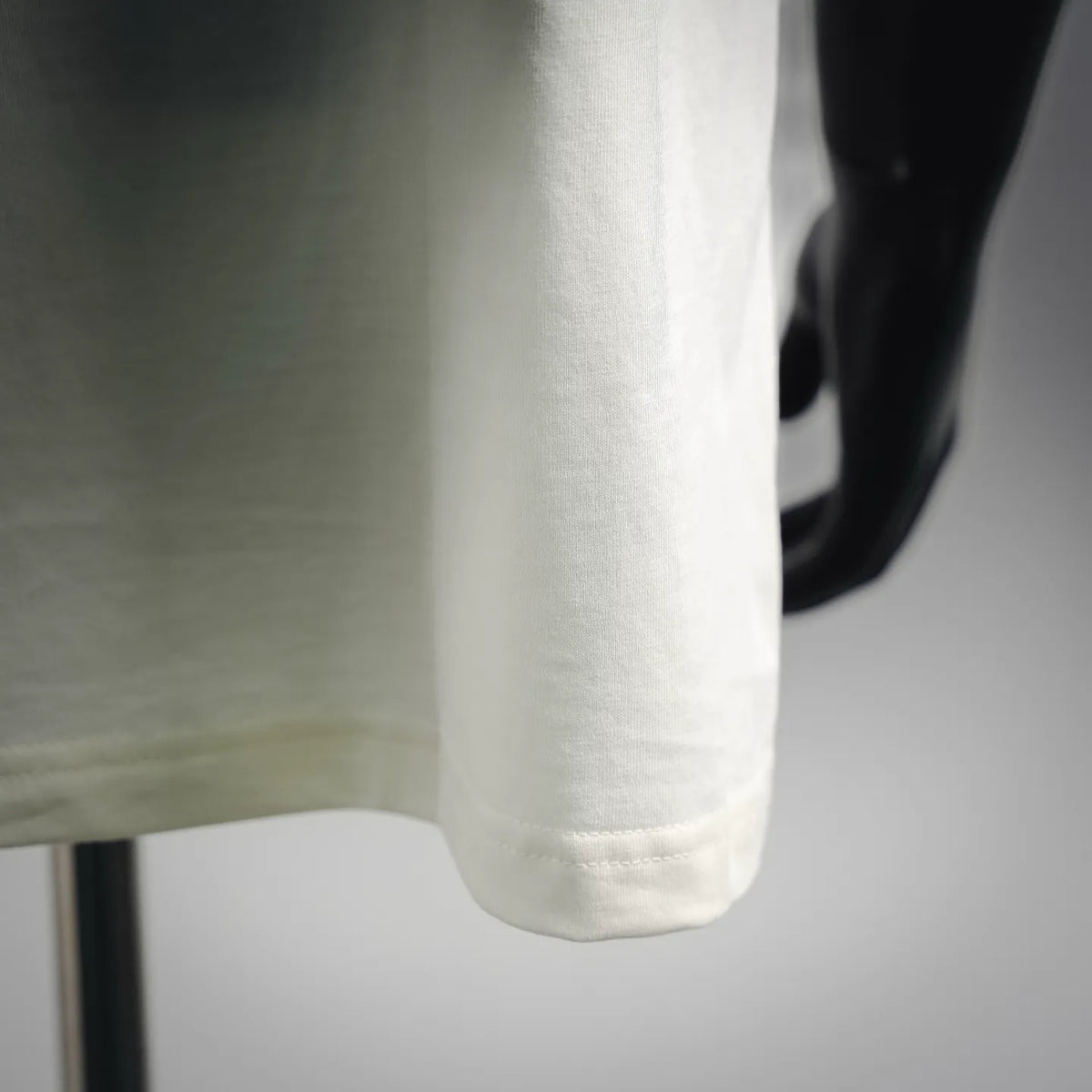 Moncler short-sleeve T-shirt, white, close-up of front hem and curved sleeve edge