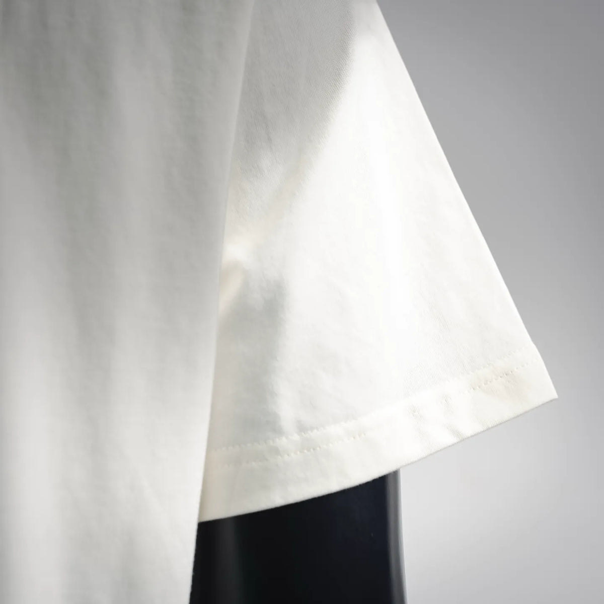 Moncler short-sleeve T-shirt, white, close-up of side seam and bottom sleeve hem