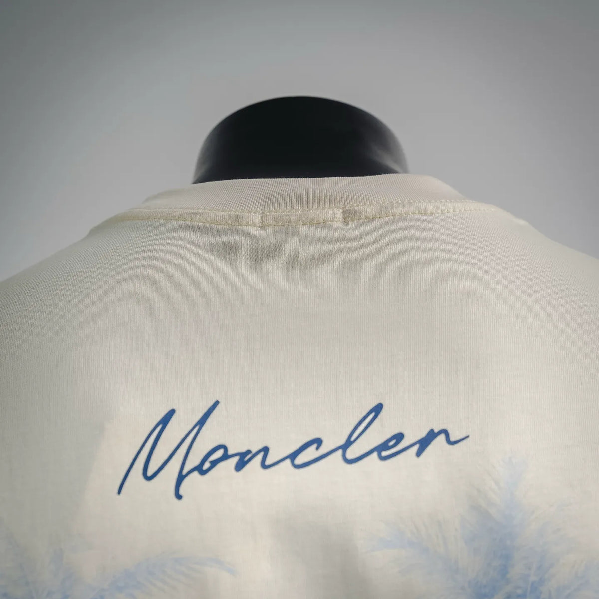 Back of white Moncler crewneck T-shirt with blue “Moncler” script