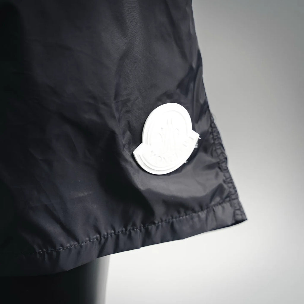 Moncler black swim shorts with round white logo patch near hem