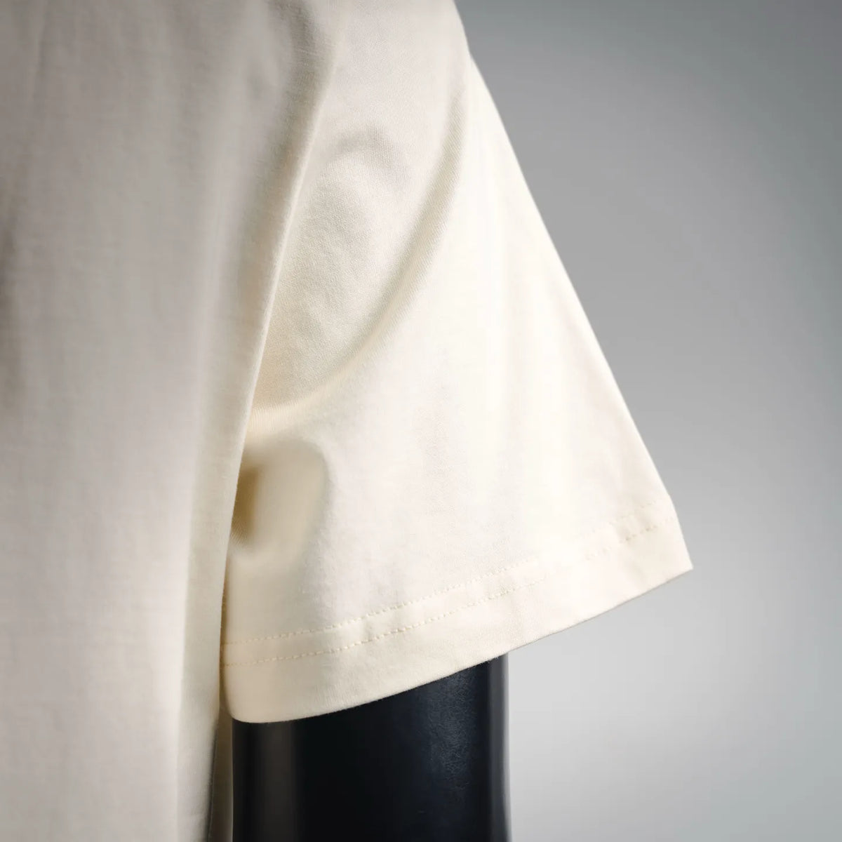 Ivory short-sleeve T-shirt sleeve hem with subtle stitching and drape