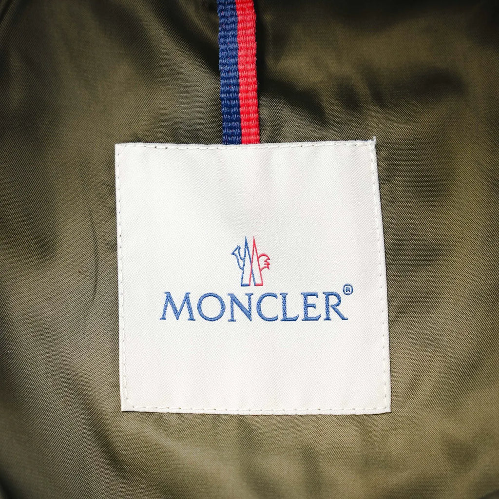 Moncler fabric label on olive green jacket with red and blue stripe trim