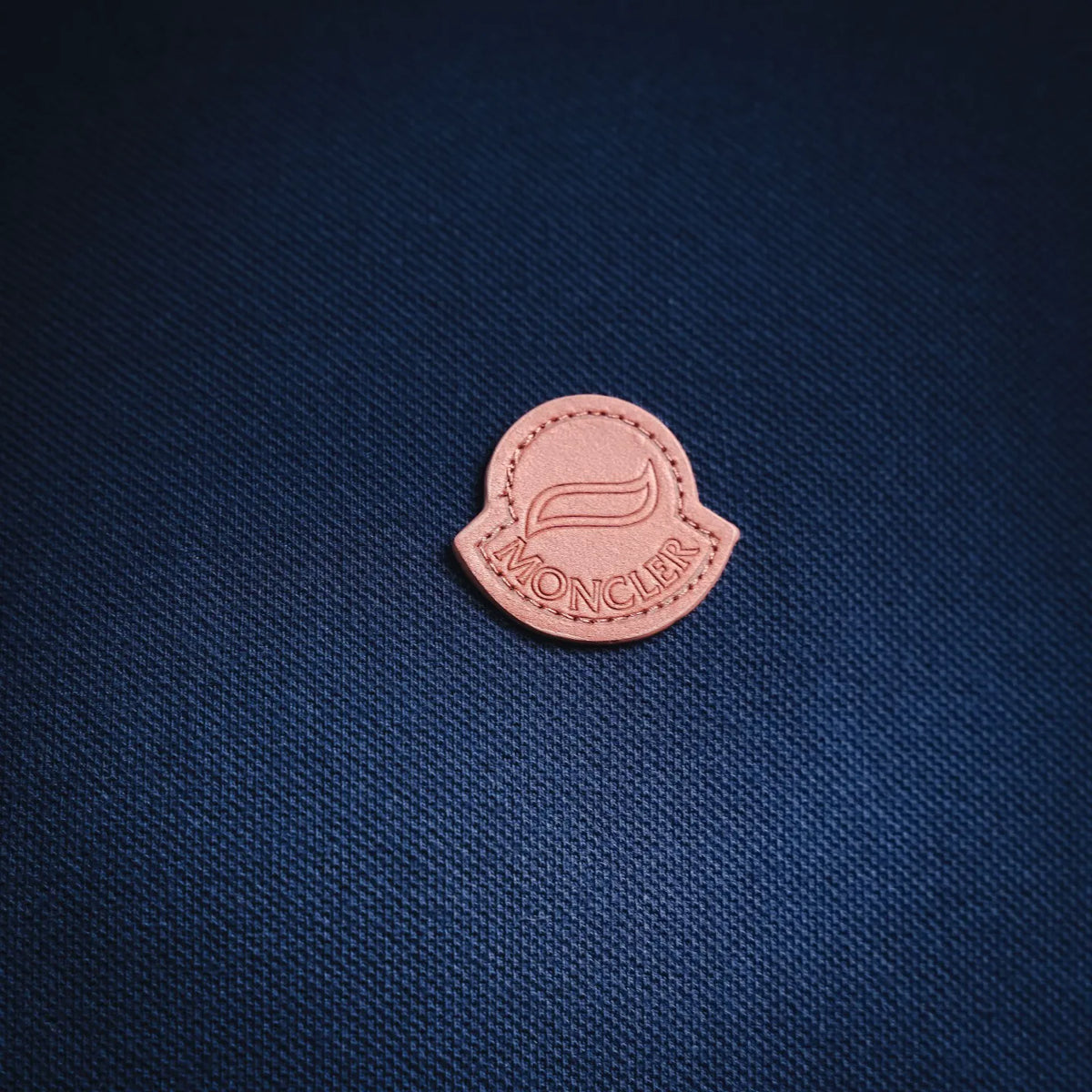 Moncler logo patch in pink on dark blue polo fabric