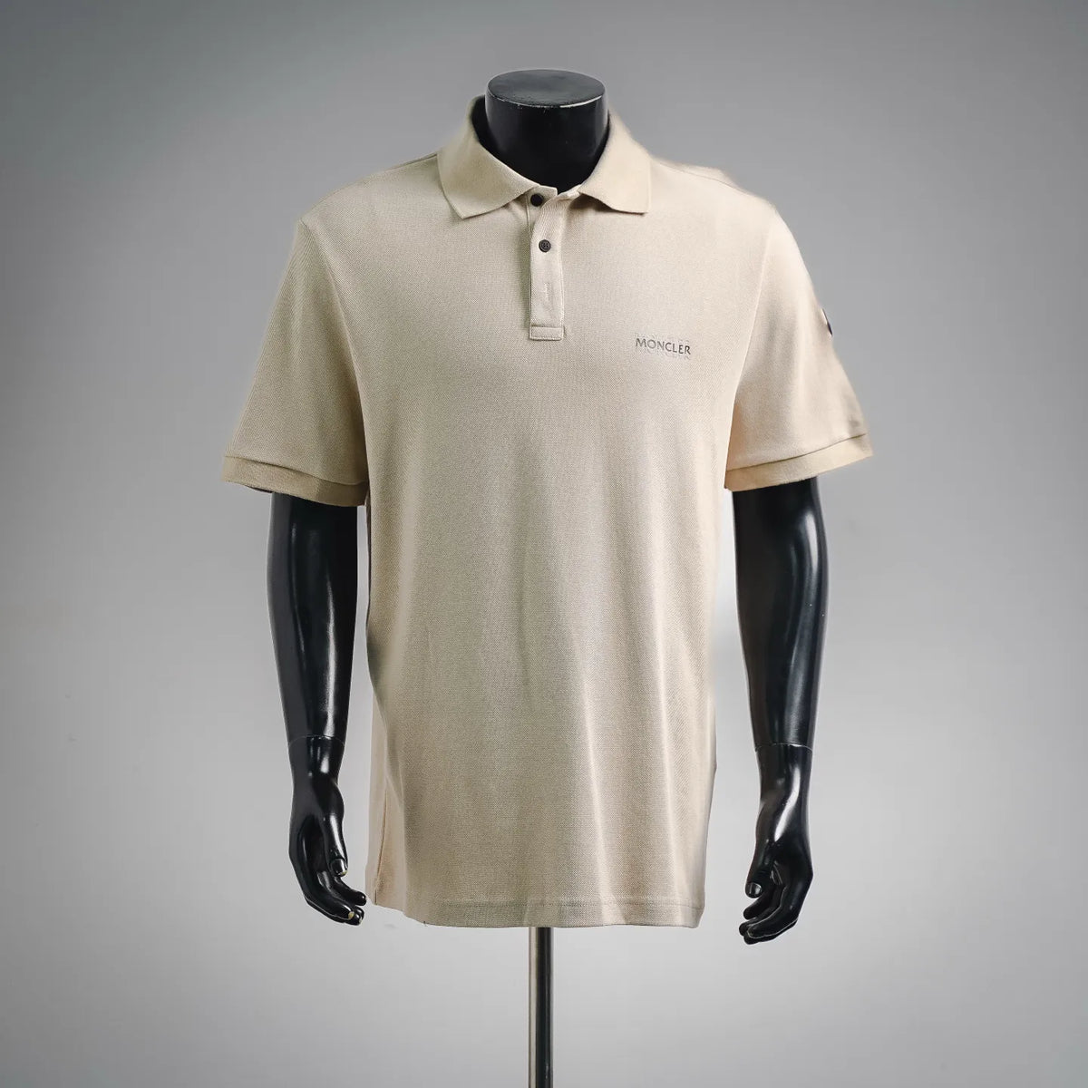 Moncler short-sleeve polo shirt in light beige with buttoned collar and chest logo.