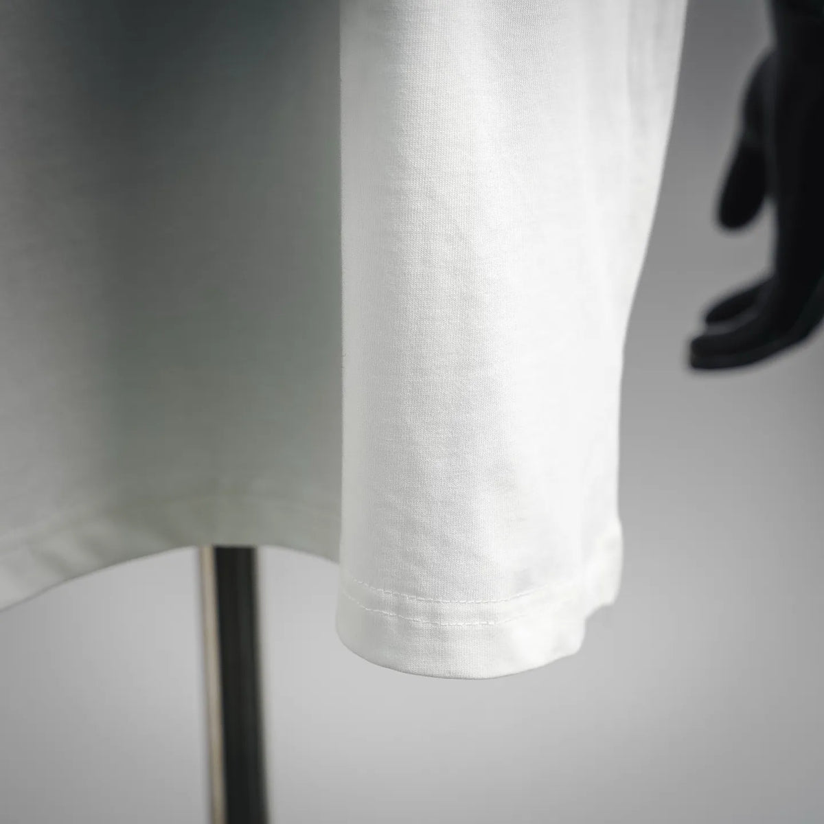 White short-sleeve T-shirt hem detail with visible fabric fold