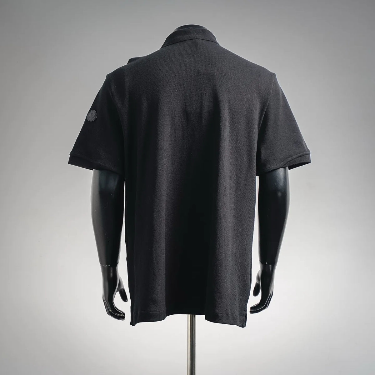 Black short-sleeve polo shirt back view with collar and sleeves
