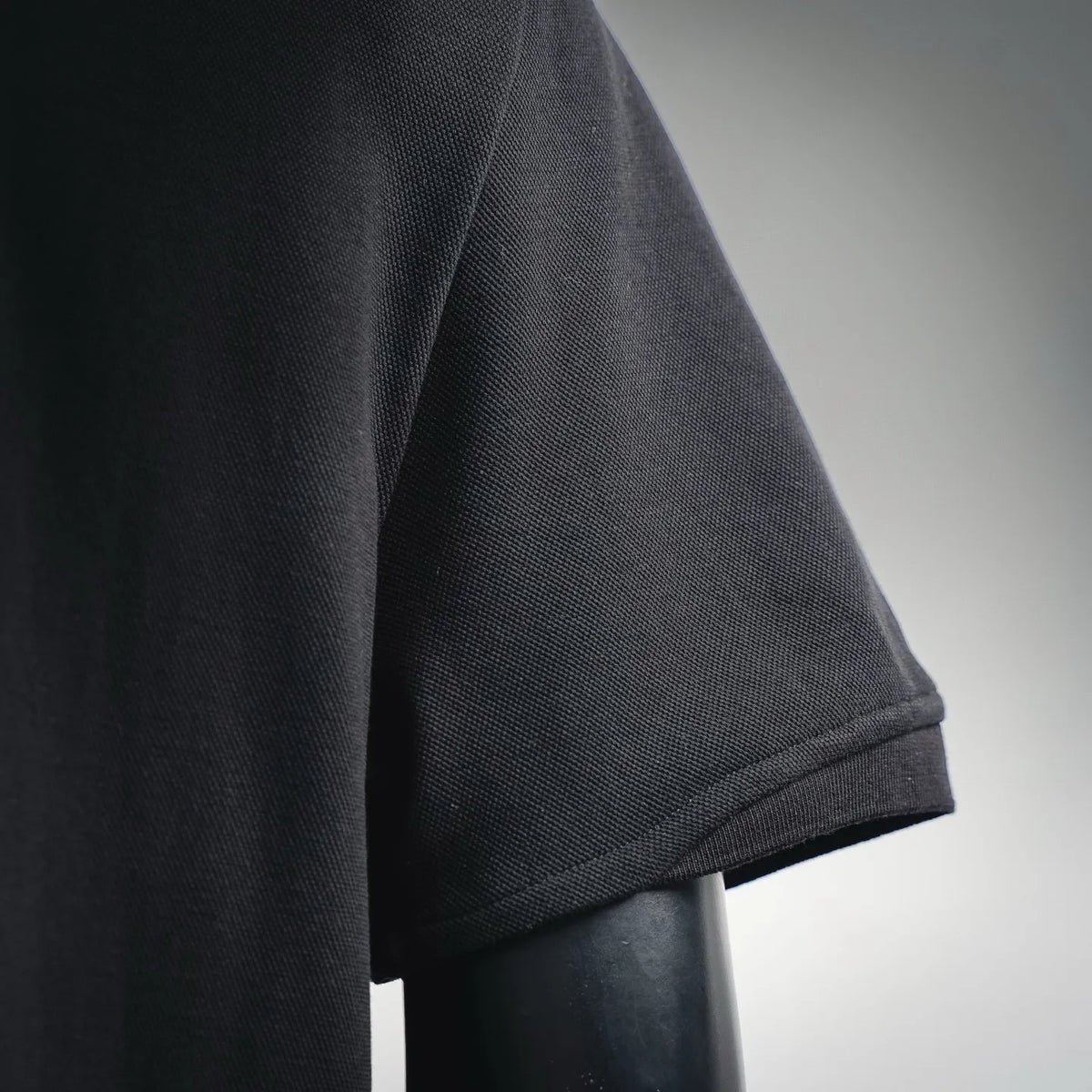 Black short-sleeve polo sleeve cuff and seam close-up