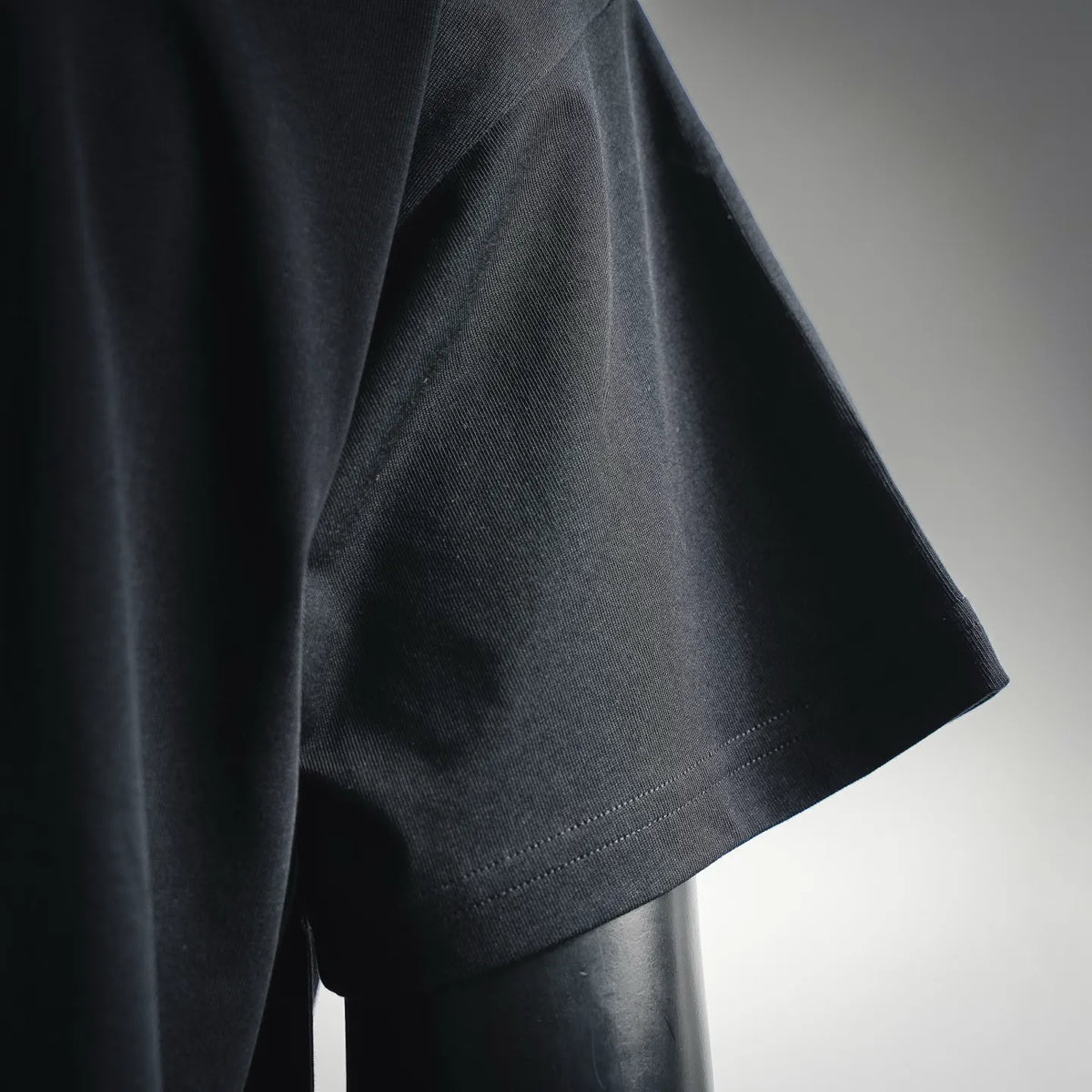 Moncler dark short-sleeve T-shirt fabric close-up, clean hem and stitched edge