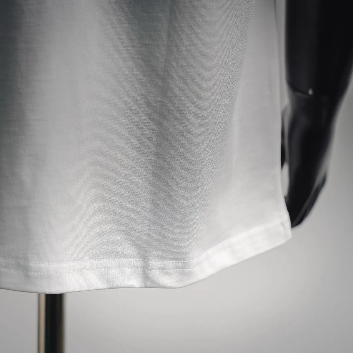 White T-shirt fabric close-up with bottom hem stitching