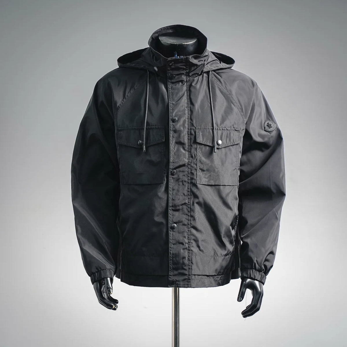 Hooded coat in dark gray with front zip, snap pockets, and drawstring hood.