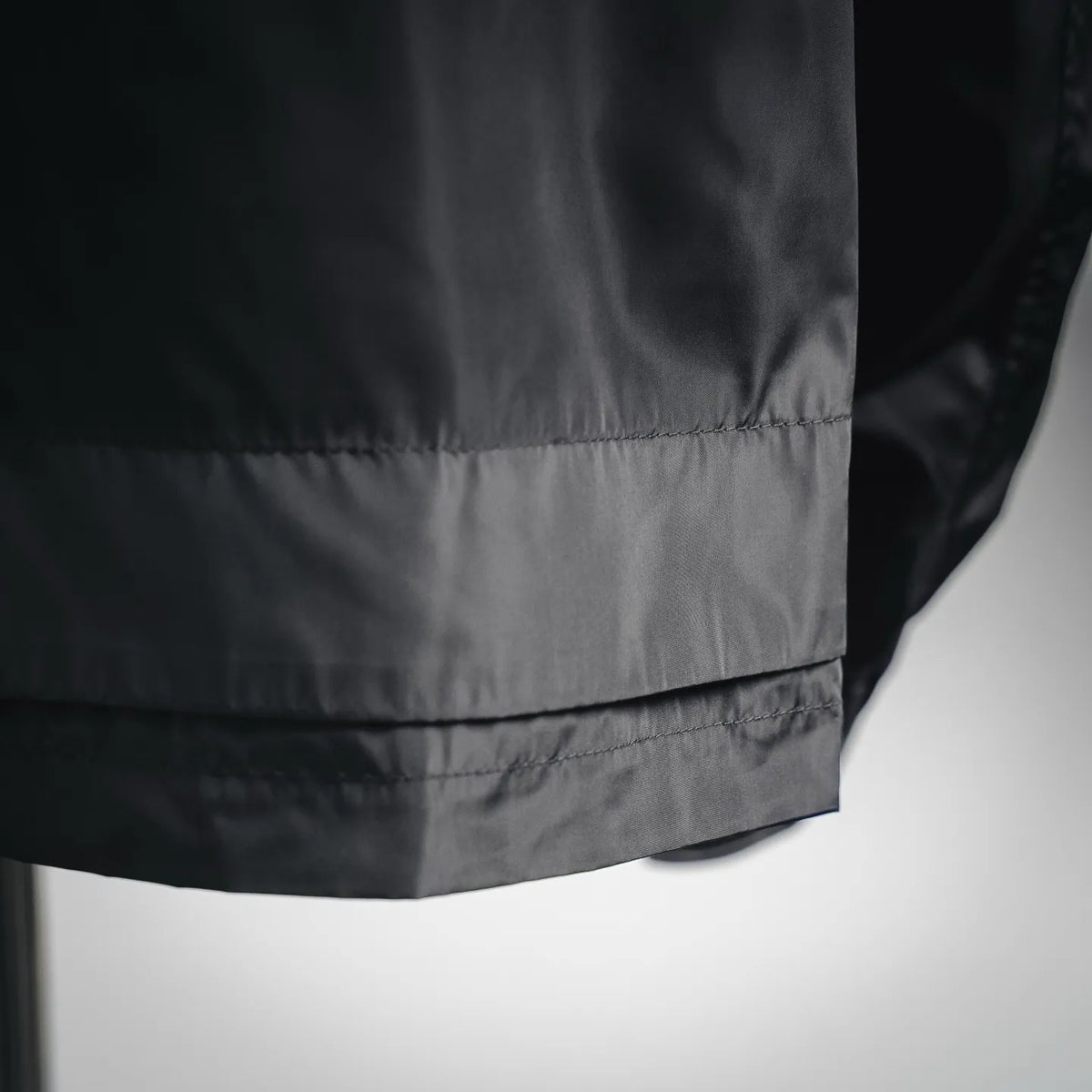 Coat lower front with elasticated waist band and smooth outer fabric.