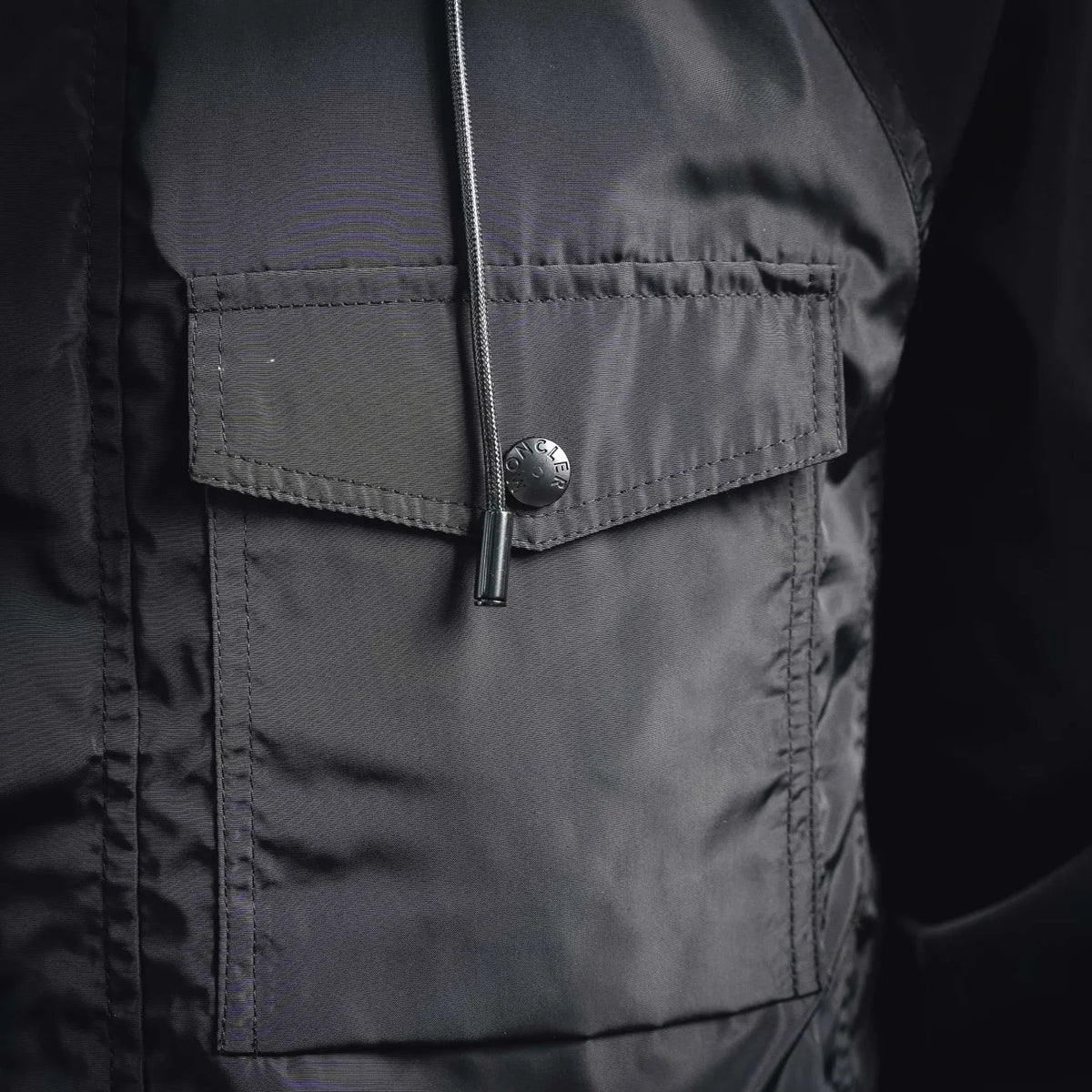 Coat front pocket area with zipper closure and stitched fabric placket.