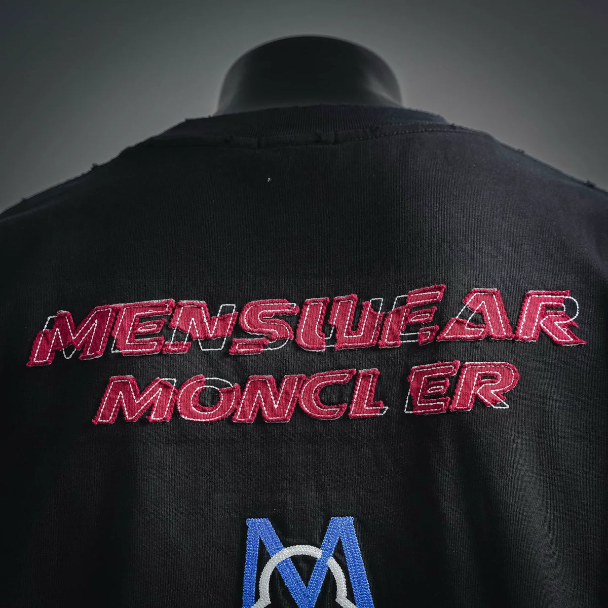 Black T-shirt back with red embroidered lettering and blue Moncler M emblem