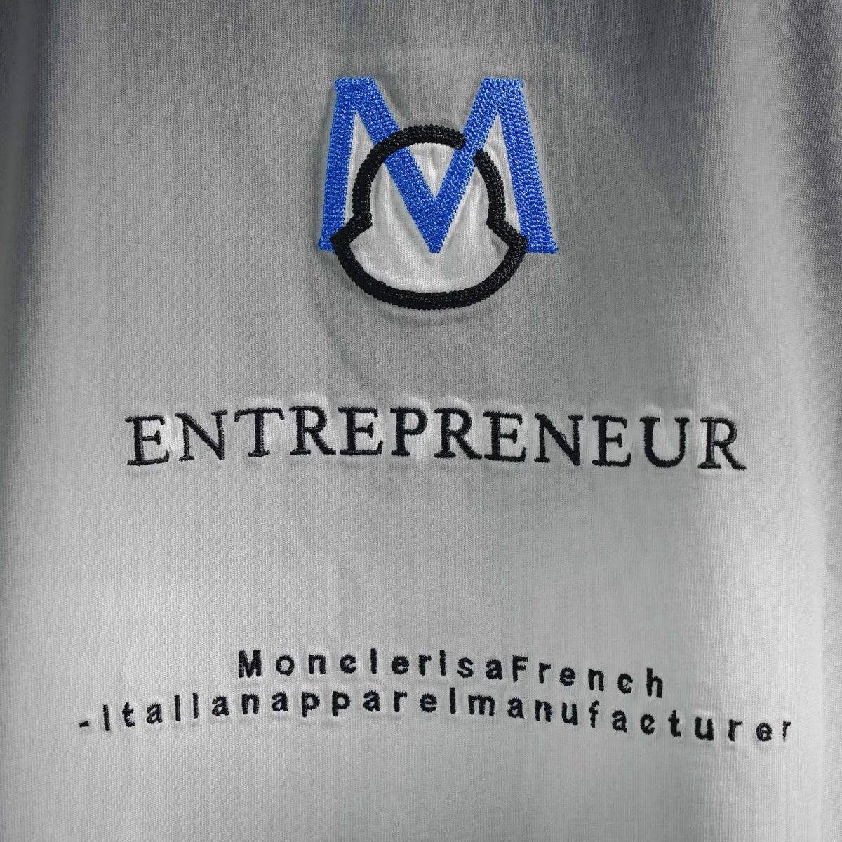 White T-shirt detail: blue M logo and 'ENTREPRENEUR' text print