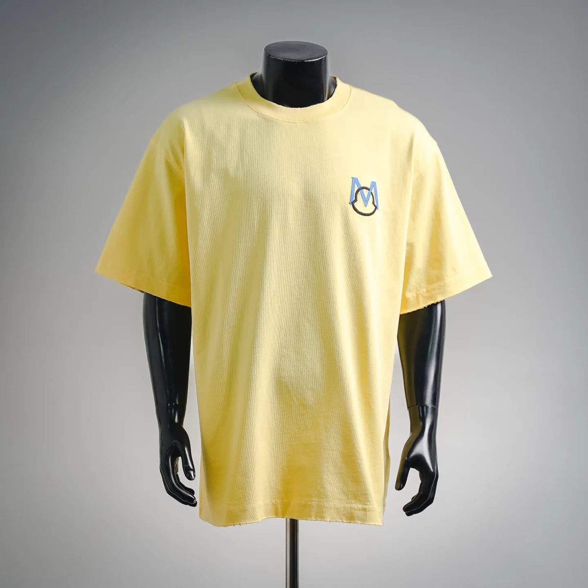 Men's yellow short-sleeve t-shirt with small blue M emblem on the chest