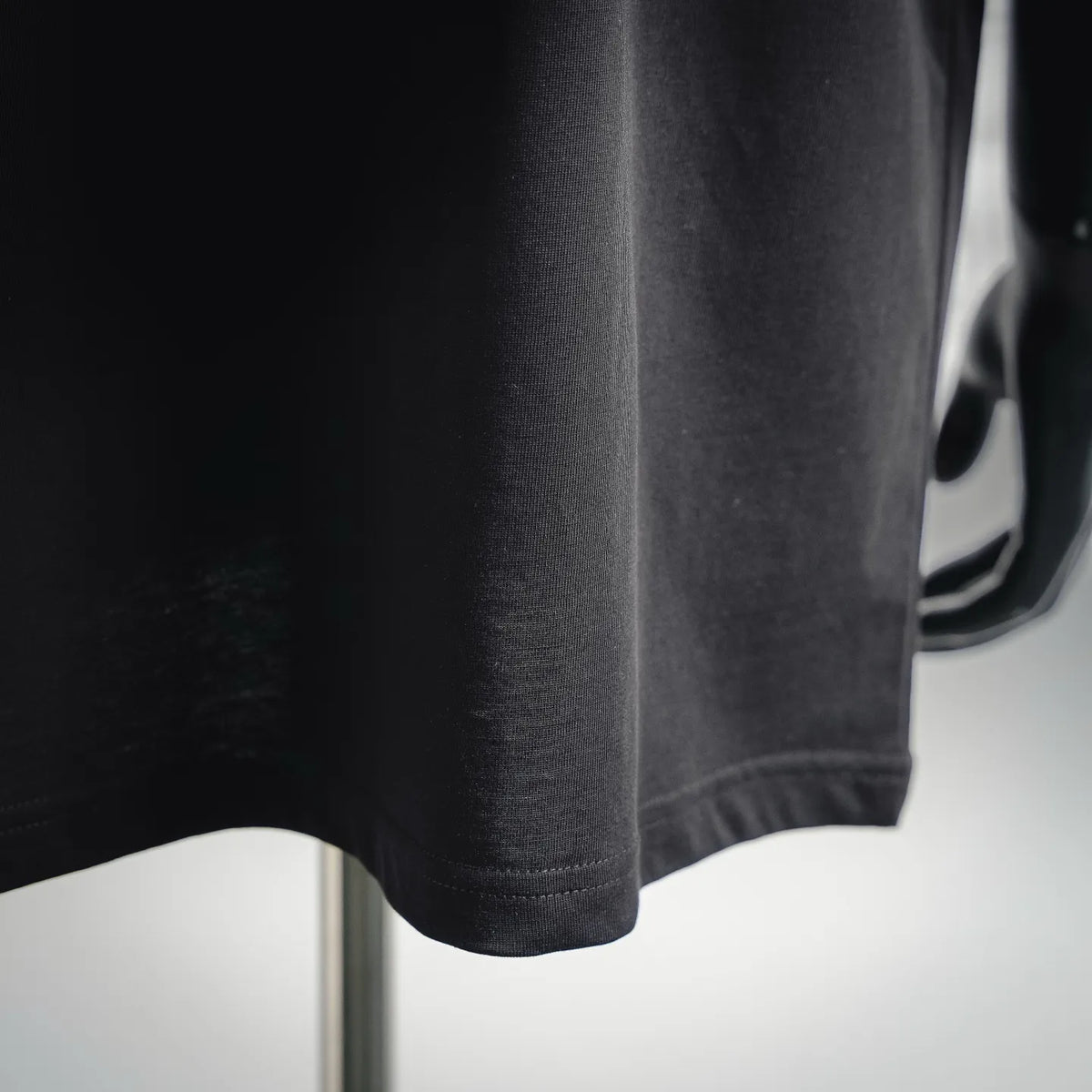 Men's Moncler short-sleeve t-shirt, black; close-up of curved hem and stitching