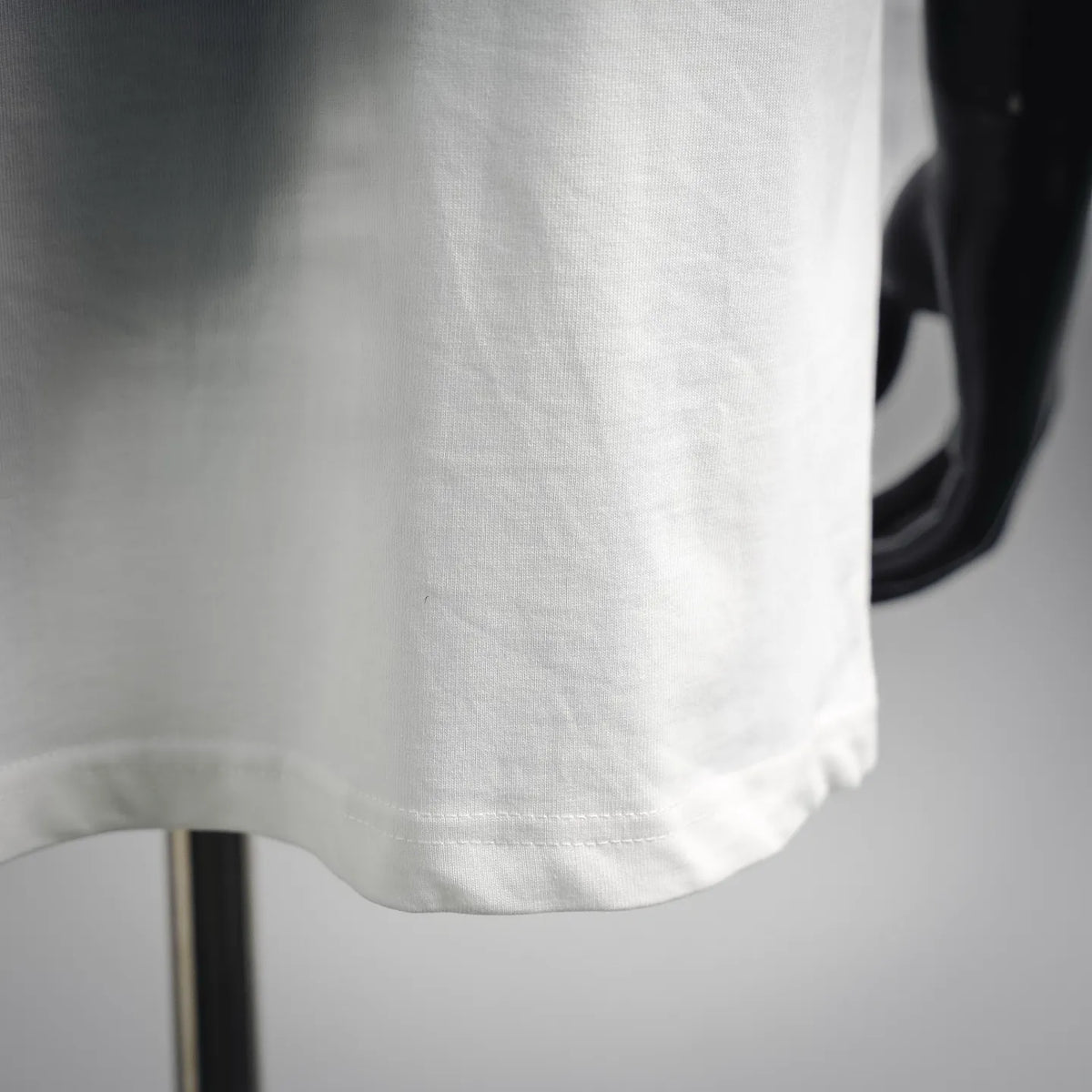 White crew-neck T-shirt hem and fabric texture close-up