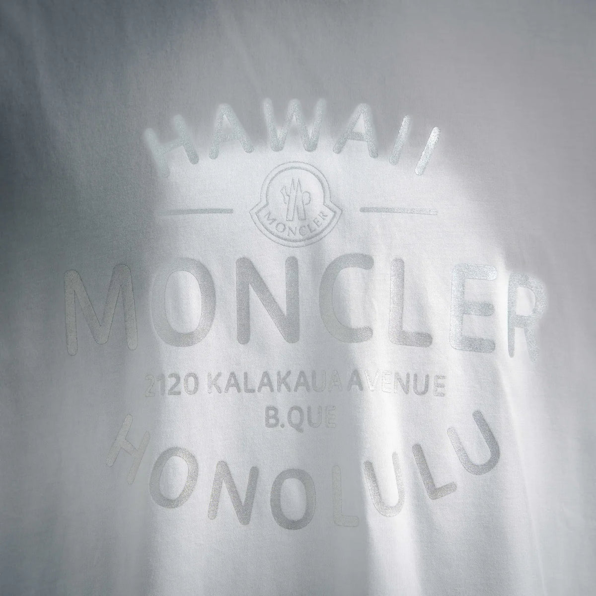 White Moncler T-shirt with large MONCLER logo graphic on the chest.