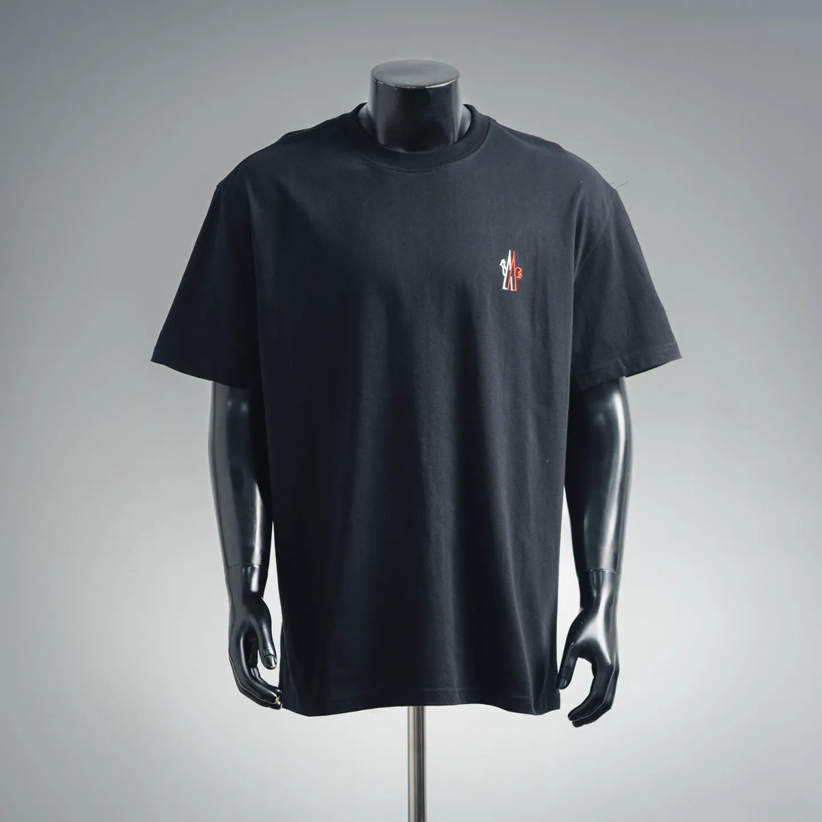 Short-sleeve T-shirt in dark color with small chest logo patch