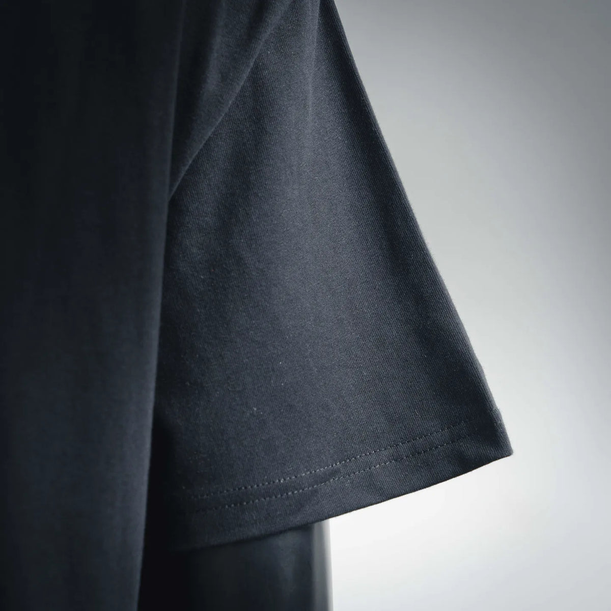Dark short-sleeve T-shirt with side seam stitching and stitched hem