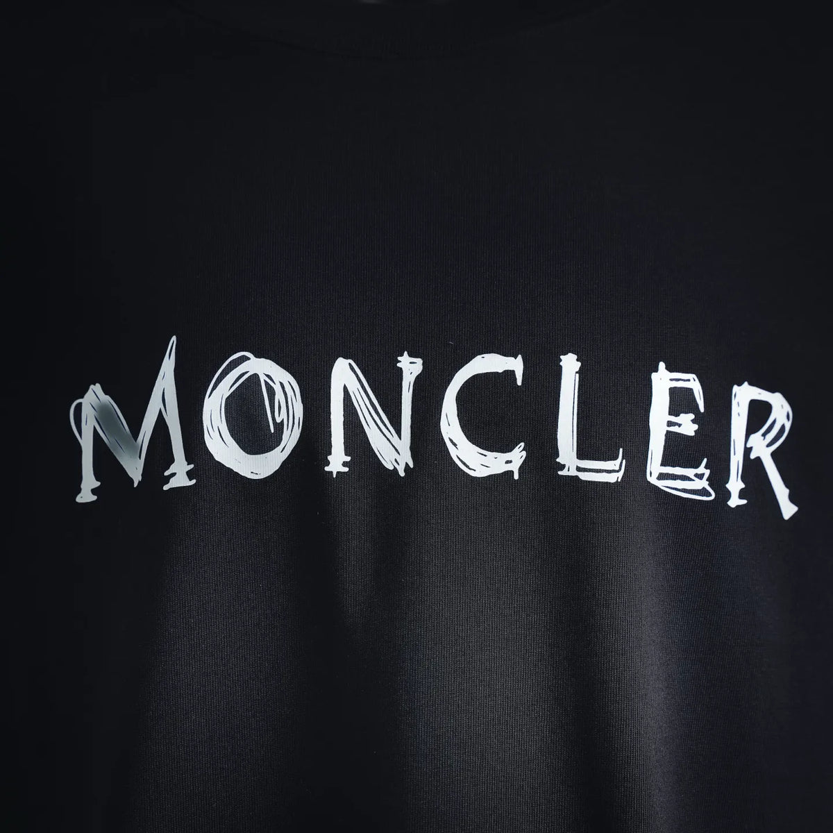Dark T-shirt with large MONCLER lettering on front
