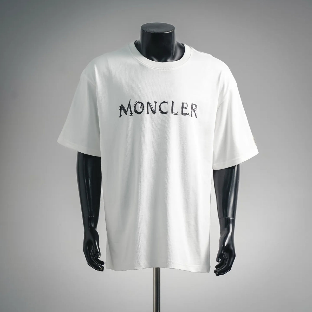White short-sleeve T-shirt with MONCLER logo graphic on the front.