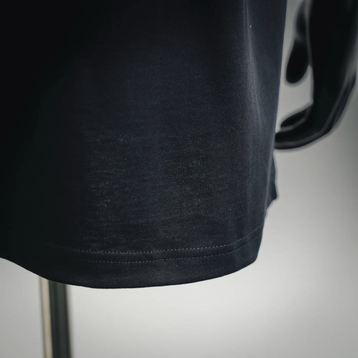 Moncler black T-shirt hem close-up with ribbed bottom band