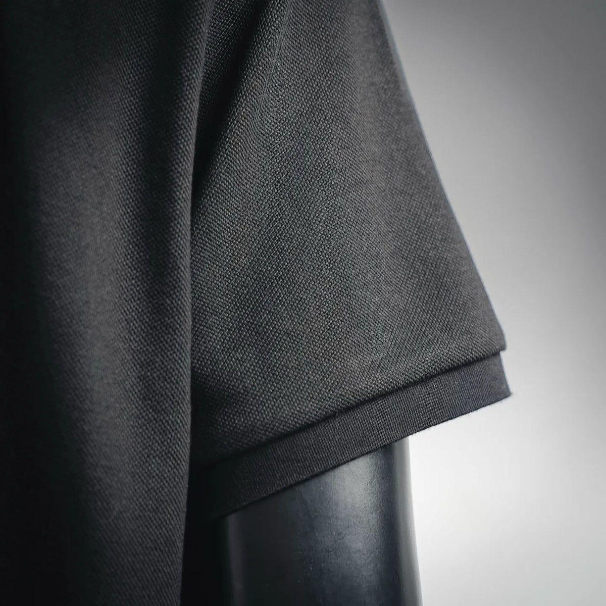 Dark polo shirt sleeve cuff with ribbed edging on short sleeve