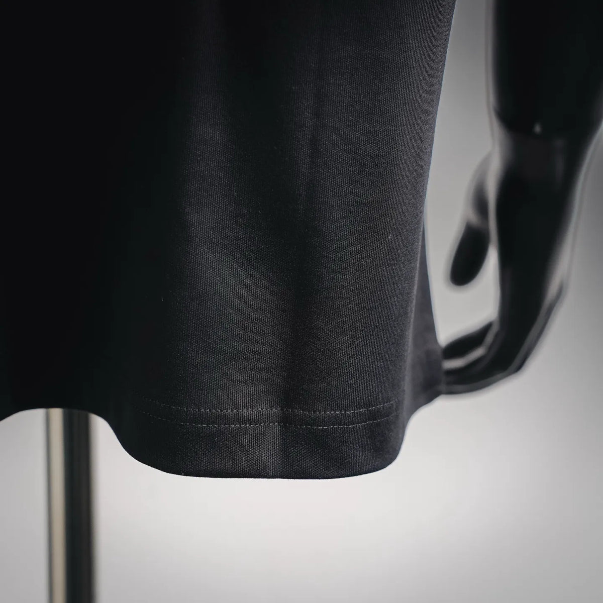 Dark short-sleeve T-shirt hem with visible stitching detail