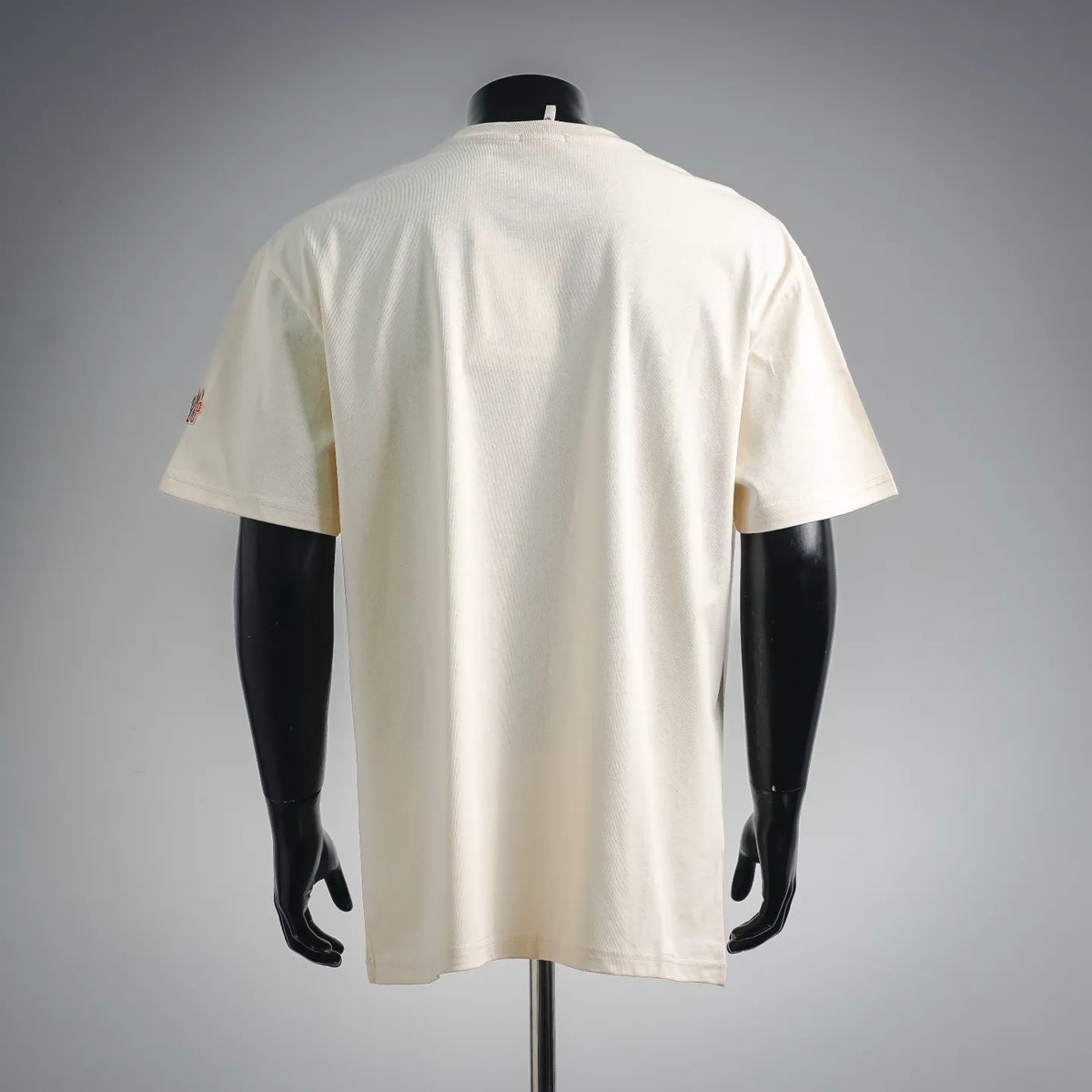 Cream short-sleeve T-shirt, back view with small rear logo detail.