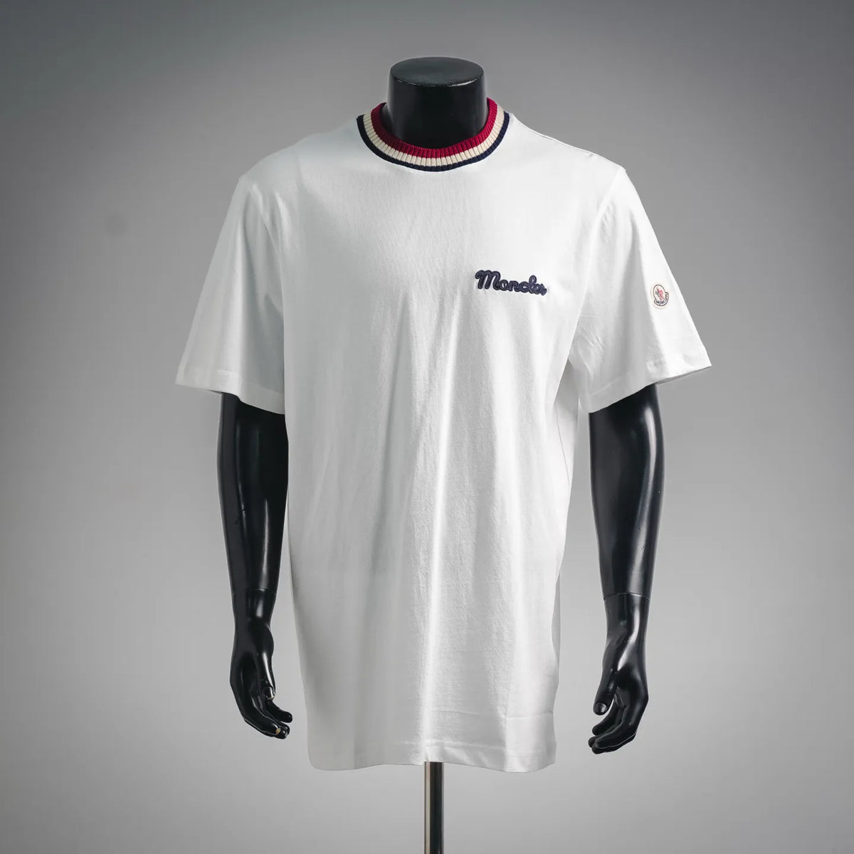 White Moncler short-sleeve T-shirt with striped ribbed collar and chest logo.