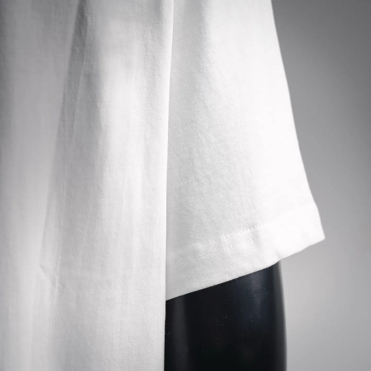 White short-sleeve T-shirt fabric and sleeve/side drape detail.