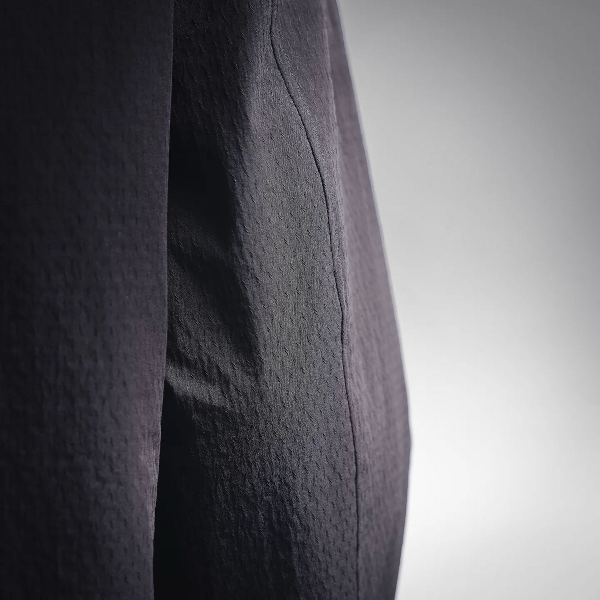 Close-up of Moncler coat fabric texture and vertical seam in dark gray