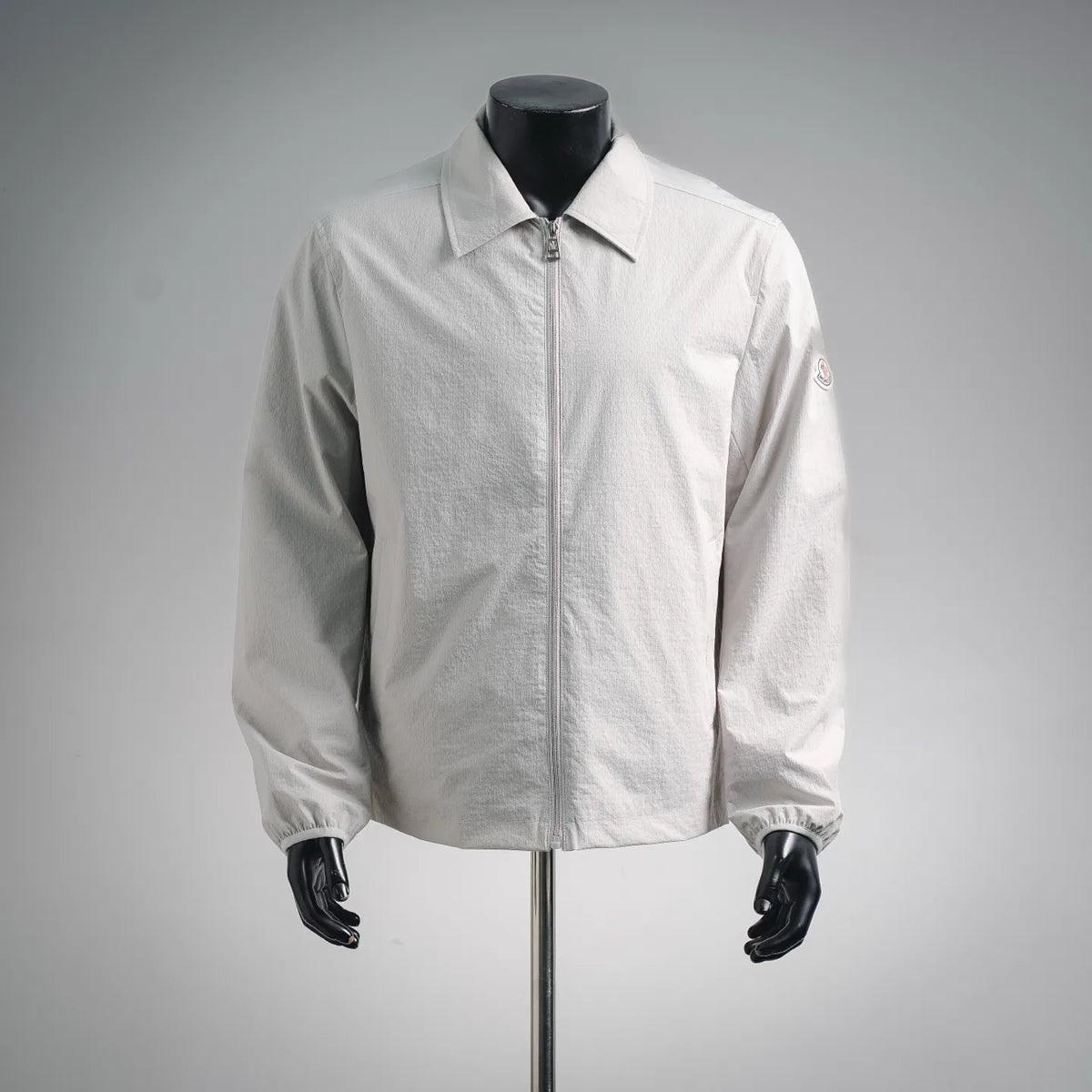 White Moncler zip-up coat with stand collar and front zipper, long sleeves
