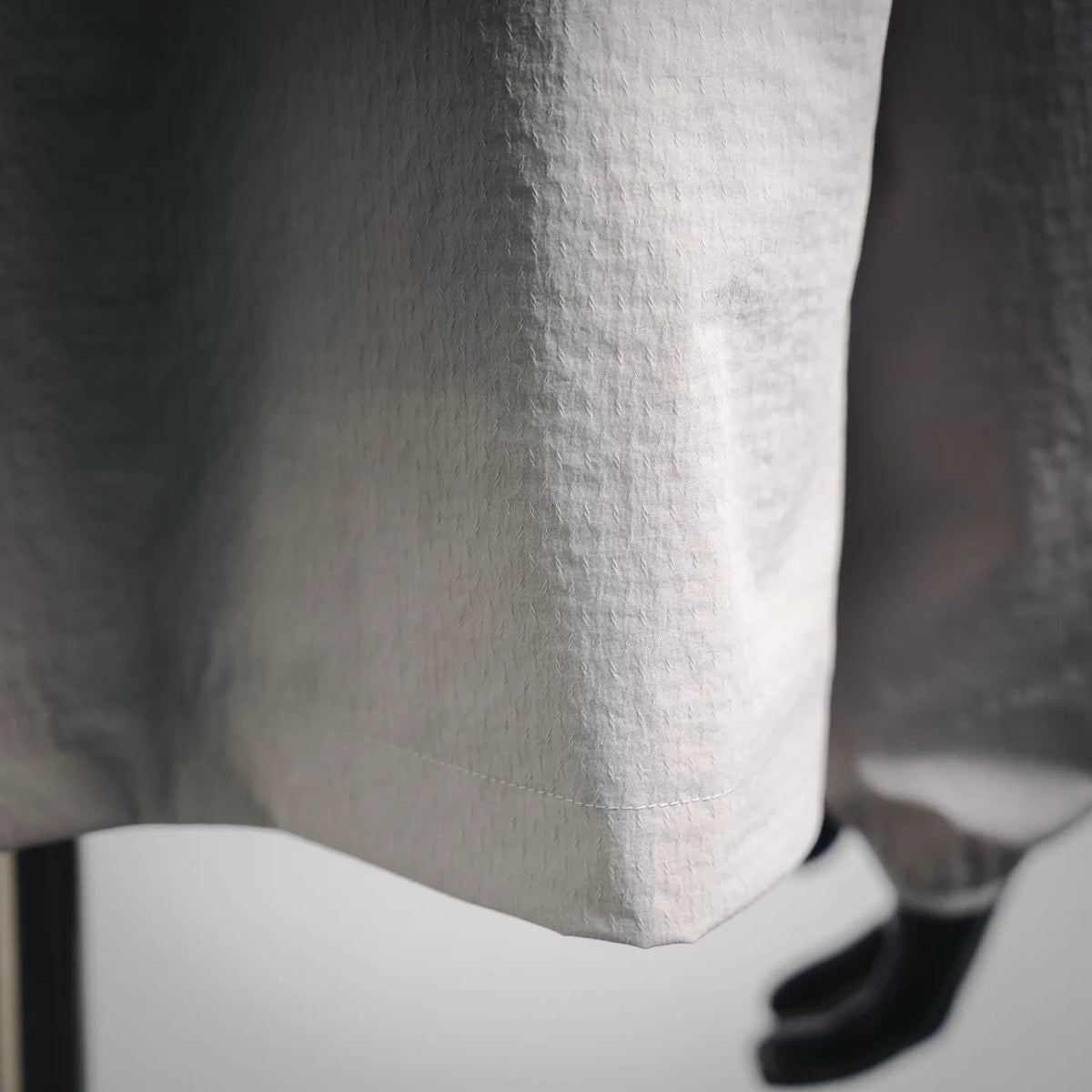 White Moncler coat hem and side fabric panel close-up