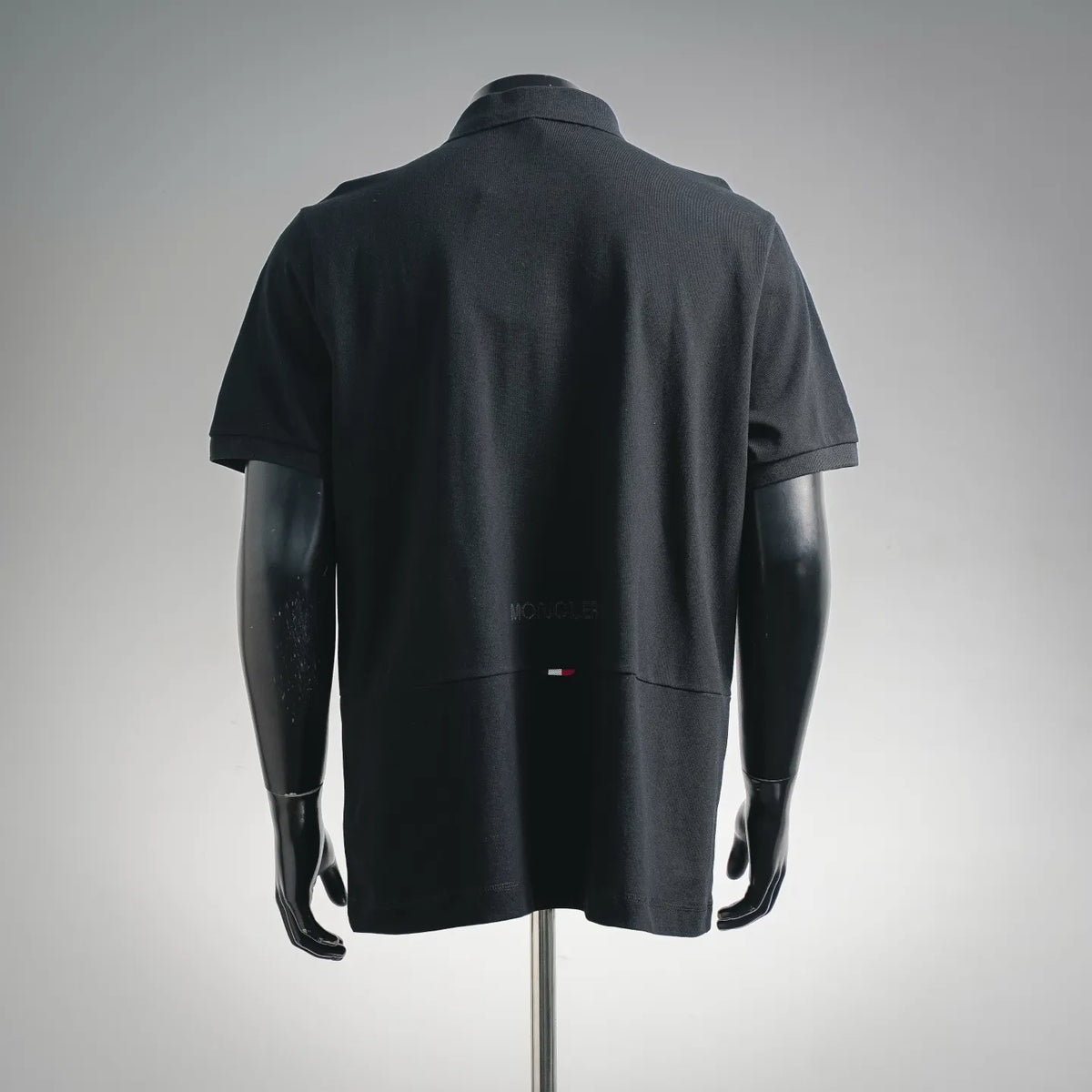 Moncler short-sleeve polo shirt back view, dark black with small rear flag detail