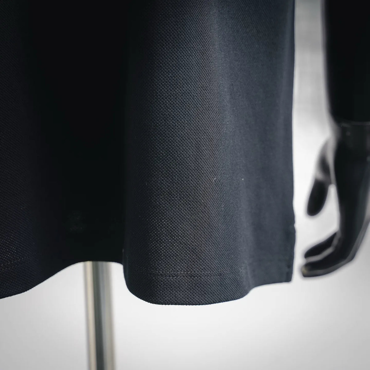 Moncler polo shirt fabric close-up in dark textured knit