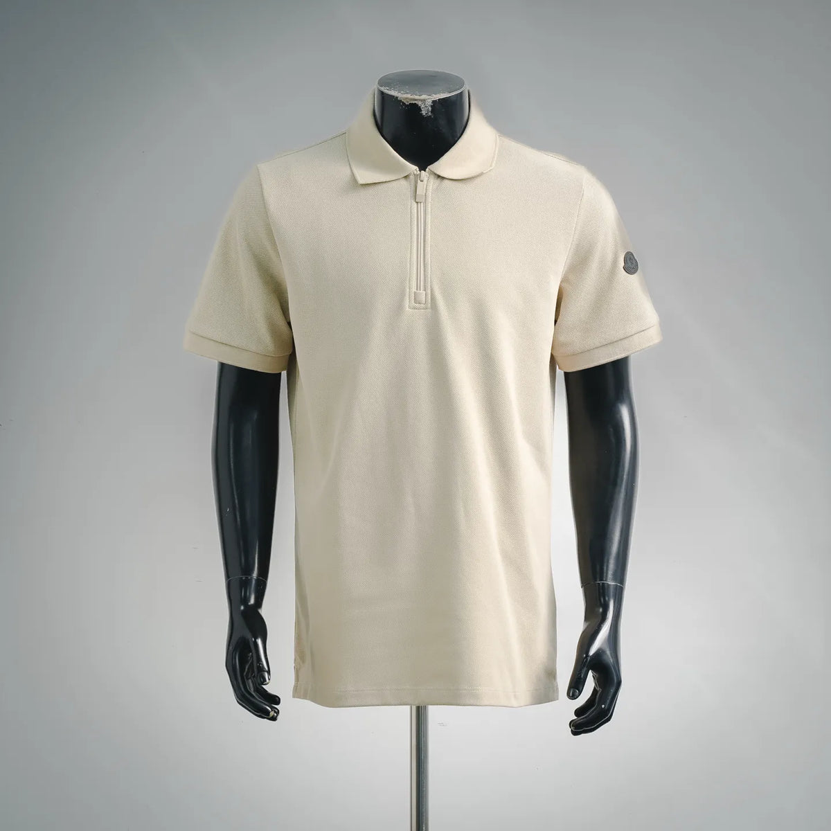 Cream polo shirt with collar, half-zip placket, and short sleeves