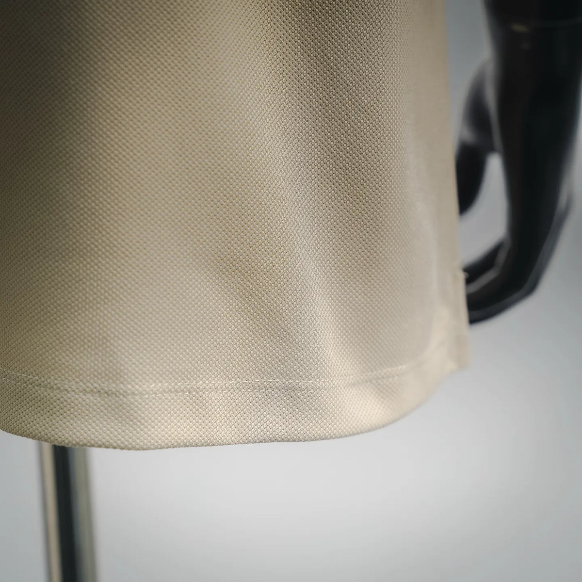 Cream textured polo fabric close-up with fine knit pattern