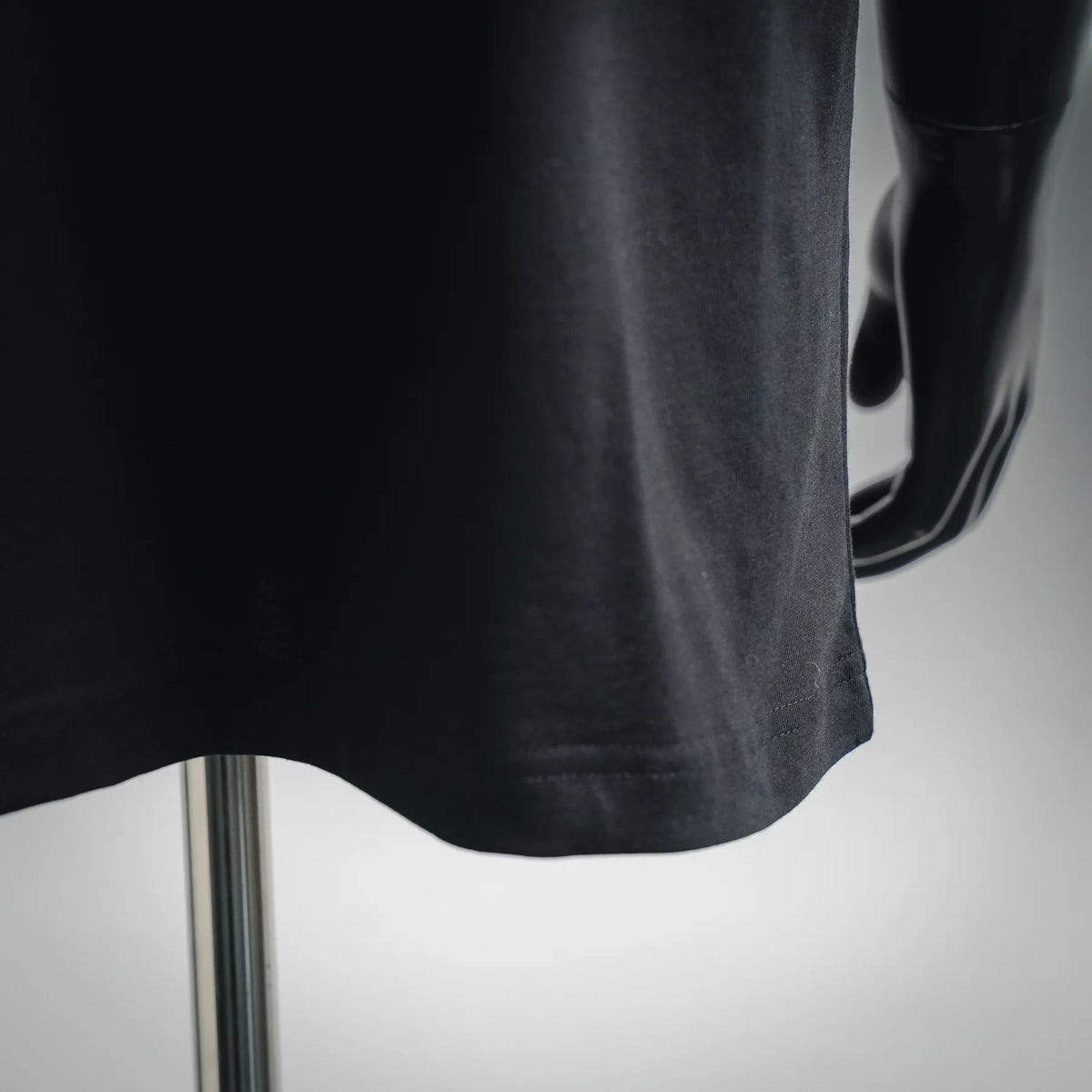 Black T-shirt hem with curved bottom and visible stitching