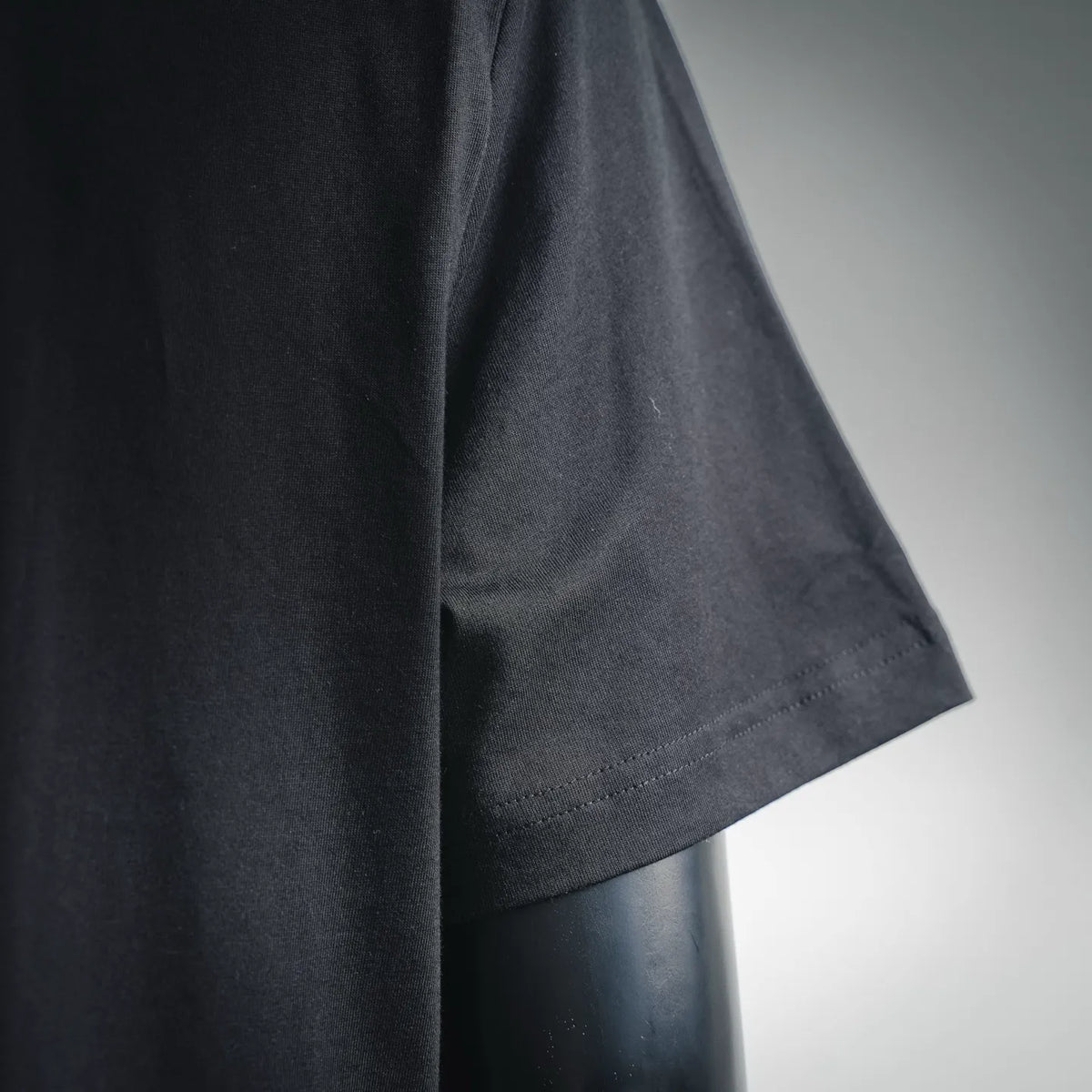 Black short-sleeve T-shirt sleeve hem and side seam close-up